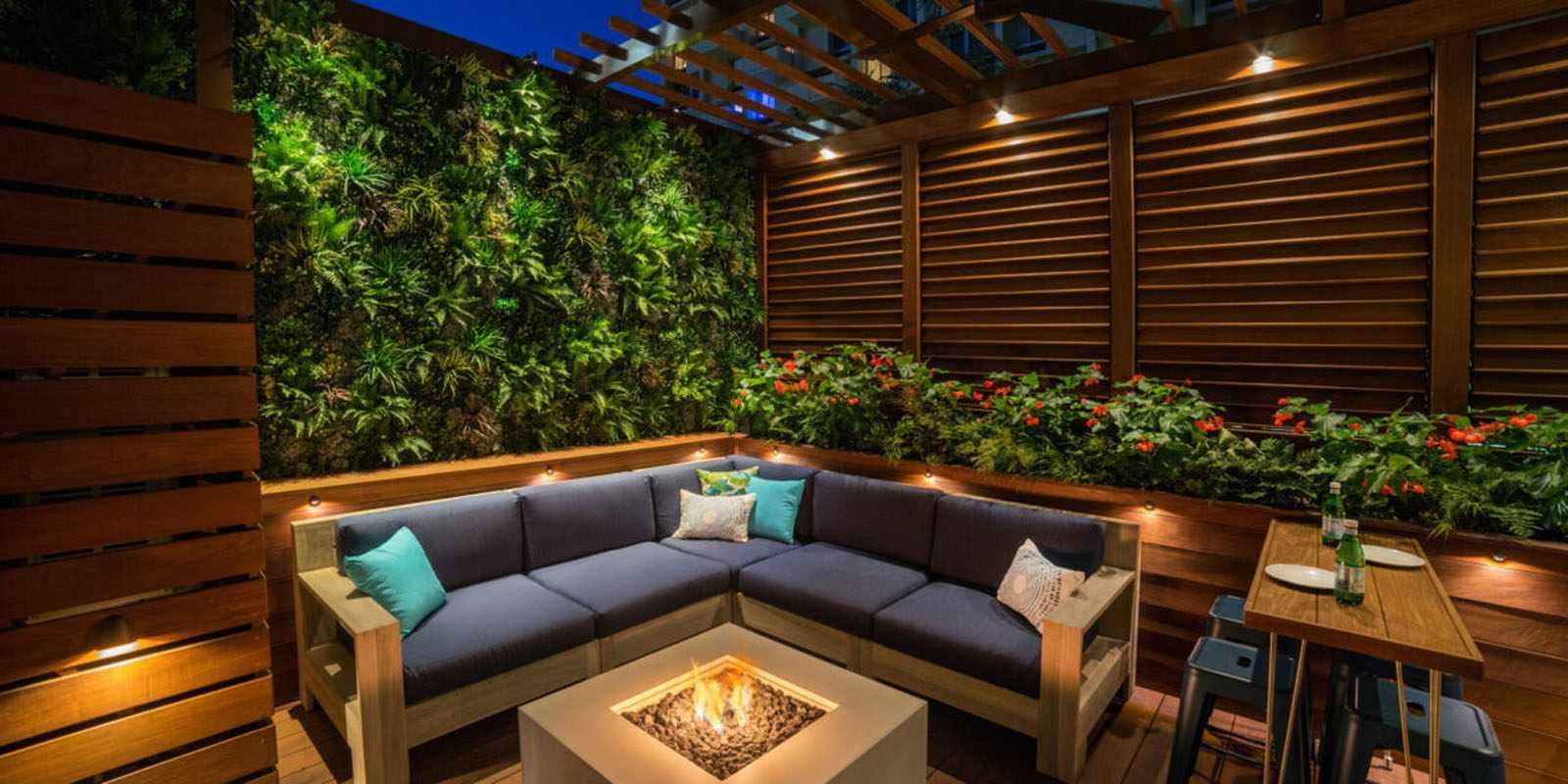 Outdoor lounge seating around a fire feature at dusk
